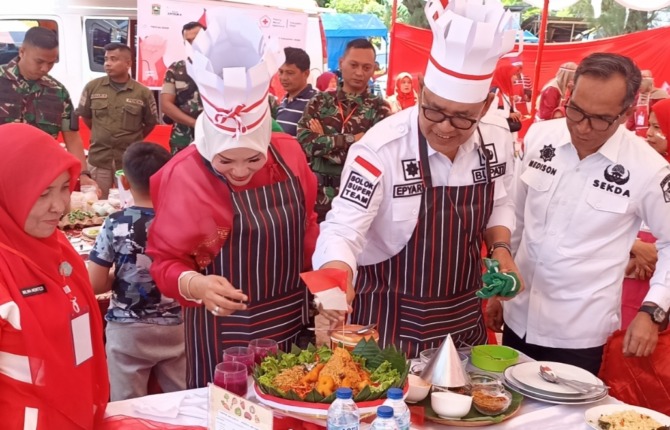 Bupati Solok Epyardi Asda dan istri disaksikan Sekkab Medison mengikuti lomba memasak nasi goreng di kawasan Dermaga Singkarak, Selasa (15/8/2023).